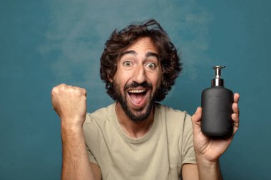 Sabun makinesi olan genç, sakallı bir adam.