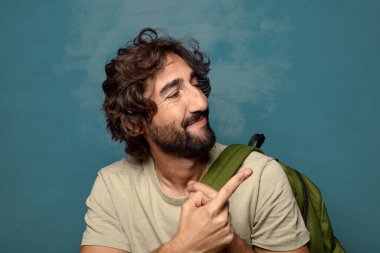 Çantası olan genç, sakallı bir adam.