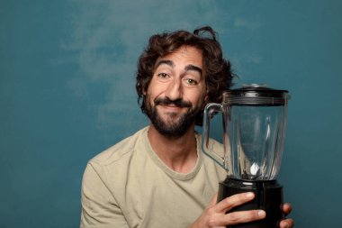 Genç, sakallı, blender makineli bir adam.