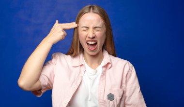 Mutsuz ve stresli görünüyor, intihar jesti elle silah işareti yapıyor, kafasını işaret ediyor.