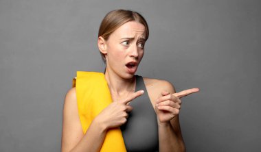 Şaşırmış ve şaşırmış hissediyorum, yan taraftaki kopyalama alanını göstererek, şaşkın ve açık ağızlı bir bakışla. fitness konsepti