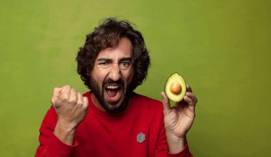 Avokadosu olan sakallı genç bir adam.
