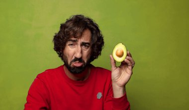 Avokadosu olan sakallı genç bir adam.