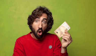 Elli avroluk banknotu olan sakallı genç bir adam.