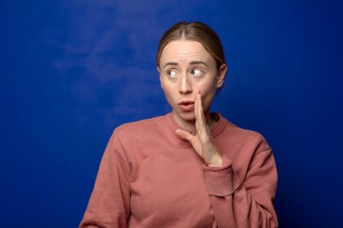 Sarışın kadın şoke olmuş ve ağzı açık halde yüz yüze inanamamaktan şaşkına dönmüş durumda.