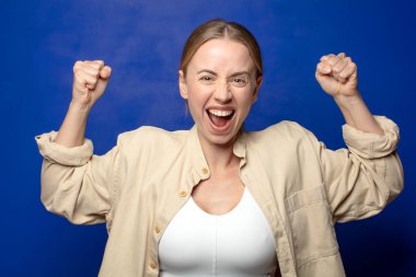 Sarışın kadın kendini mutlu, tatmin olmuş ve güçlü hissediyor, kaslı ve formda, spor salonundan sonra güçlü görünüyor.