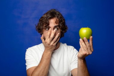 Elma tutan genç, sakallı adam.