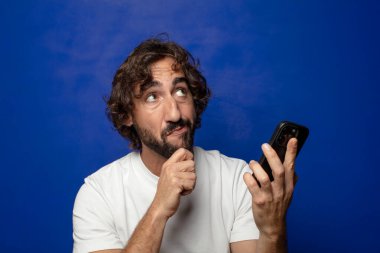 Akıllı telefonu olan genç, sakallı bir adam.