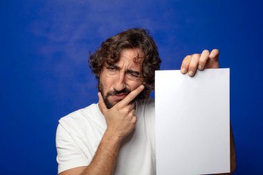 Genç, sakallı bir adam elinde bir kağıt tutuyordu.