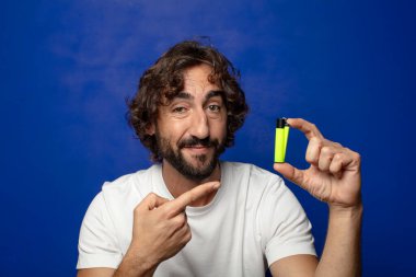 Genç, sakallı ve çakmaklı bir adam.