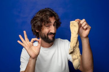 Kirli çorabı olan genç, sakallı bir adam.