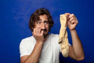 Kirli çorabı olan genç, sakallı bir adam.