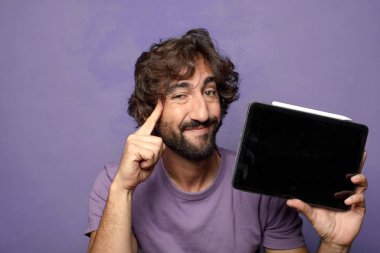 Genç, sakallı, dokunmatik ekranı tutan bir adam.