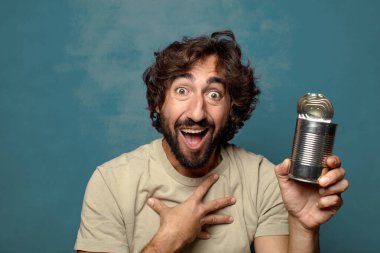 Genç, sakallı, çelik tenekeli adam.