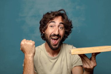 Boş tahta kesim masası olan genç, sakallı bir adam.