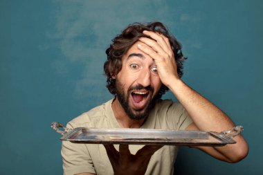 Gümüş tepsisi olan genç, sakallı bir adam.