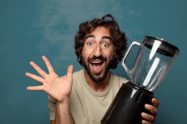 Genç, sakallı, blender makineli bir adam.