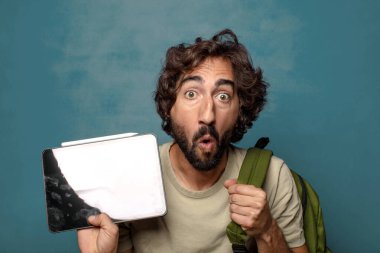 Çantası olan genç, sakallı bir adam.