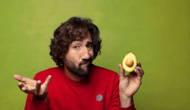 Avokadosu olan sakallı genç bir adam.