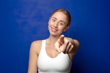 Tatmin olmuş, kendine güvenen, dostça gülümseyen ve seni seçen sarışın bir kadın.