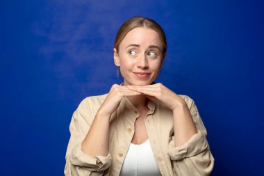 Sarışın kadın düşünceli, meraklı ya da hayal kuruyor, hayal kuruyor ve mekanı kopyalamak için yukarı bakıyor.