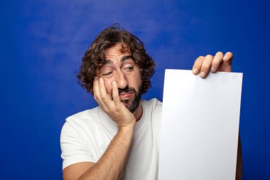 Genç, sakallı bir adam elinde bir kağıt tutuyordu.