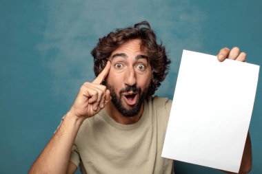 Genç, sakallı, elinde kağıt olan bir adam.