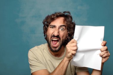 Genç, sakallı, elinde kağıt olan bir adam.