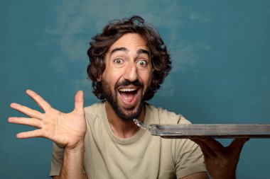 Gümüş tepsisi olan genç, sakallı bir adam.