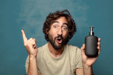 Sabun makinesi olan genç, sakallı bir adam.