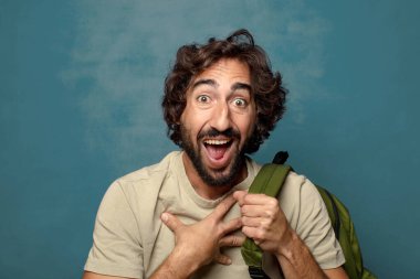 Çantası olan genç, sakallı bir adam.