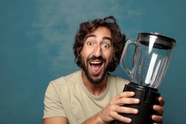 Genç, sakallı, blender makineli bir adam.