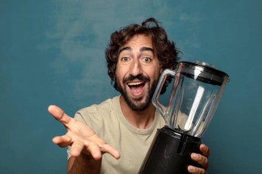 Genç, sakallı, blender makineli bir adam.