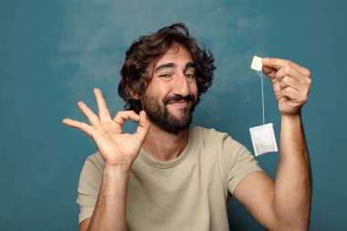 Genç, sakallı, çay içen bir adam.