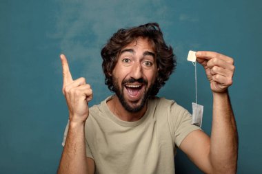 Genç, sakallı, çay içen bir adam.