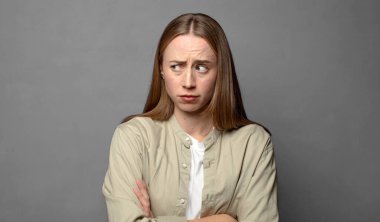 Hoşnutsuz ve hayal kırıklığına uğramış hissediyorum, ciddi görünüyor, kızgın ve çapraz kollara kızgın.