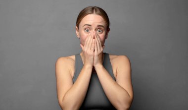 Mutlu, neşeli, şanslı ve her iki elinle ağzını kapatırken şaşırmış görünüyorsun. fitness konsepti