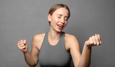 Gülümsüyor, kaygısız hissediyor, rahat ve mutlu, dans ediyor ve müzik dinliyor, bir partide eğleniyor. fitness konsepti