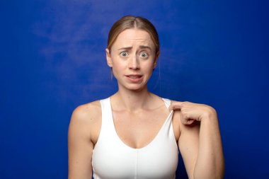 sarışın kadın stresli, endişeli, yorgun ve hayal kırıklığına uğramış, gömleğini çekiştiren, sıkıntılı görünen