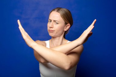 Sarışın kadın senin tavırlarından rahatsız ve bıkkın görünüyor, yeter artık! Eller önde çapraz, durmanı söylüyor.