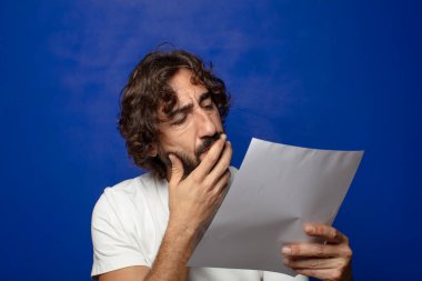 Genç, sakallı bir adam elinde bir kağıt tutuyordu.