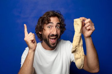 Kirli çorabı olan genç, sakallı bir adam.