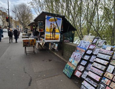 Kitap tezgahları, resim posterleri ve sokak sanatı. Seine nehrinin yanında gezginler ve koleksiyoncular için bir cazibe ve cazibe var. Paris, Fransa, 2023-03-30