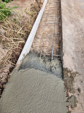 Yolu güçlendirmek yolu genişletmek için çimento dökmek. Kaldırımı genişletmek için yolu tutan çelik bir çerçeve olacak..