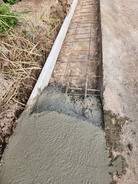 Yolu güçlendirmek yolu genişletmek için çimento dökmek. Kaldırımı genişletmek için yolu tutan çelik bir çerçeve olacak..