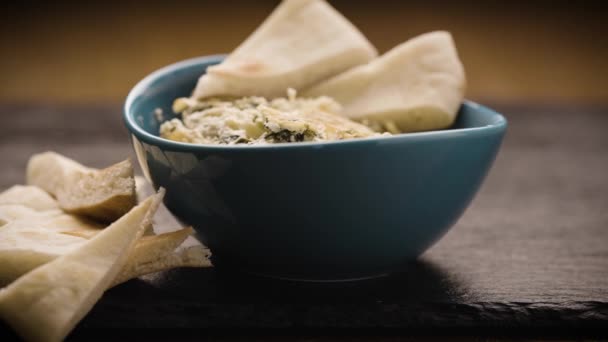 烤菠菜和朝鲜蓟蘸在用三角皮面包装饰的茶色小碗里 — 图库视频影像