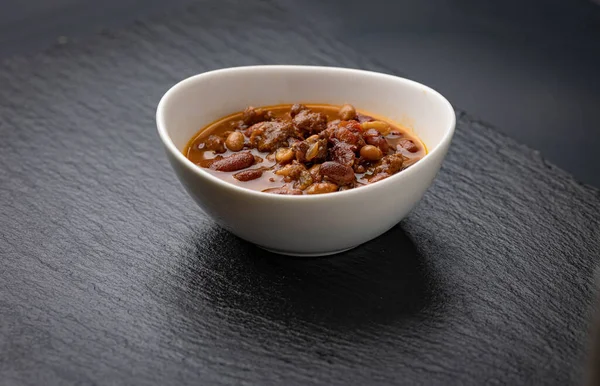 Bowl of chili on black background