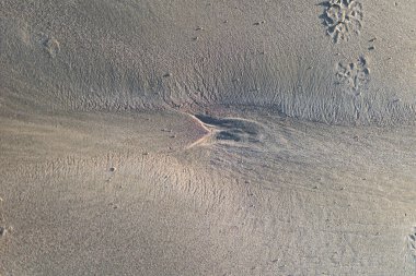 Kumlu kumlu sahil dokusu ve deniz yapısı yüzeyi.