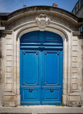 Eski mavi ahşap kapılar, taş duvarda mavi boya.