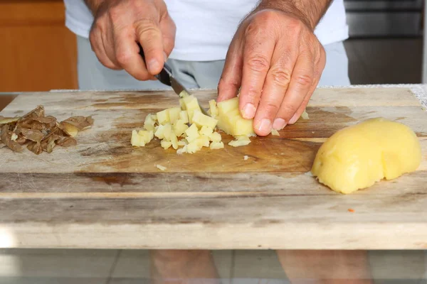 man preparing potatoes in the kitchen